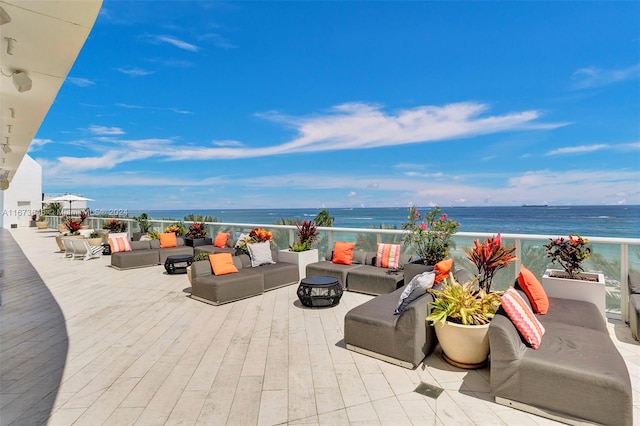 view of patio with a water view, an outdoor living space, and a view of the beach