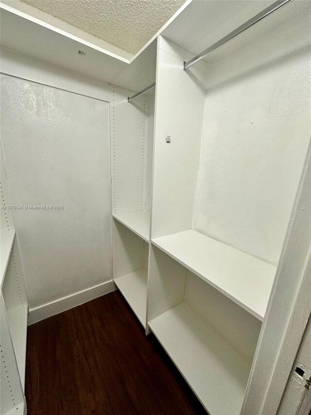 unfurnished room with wood-type flooring and a textured ceiling