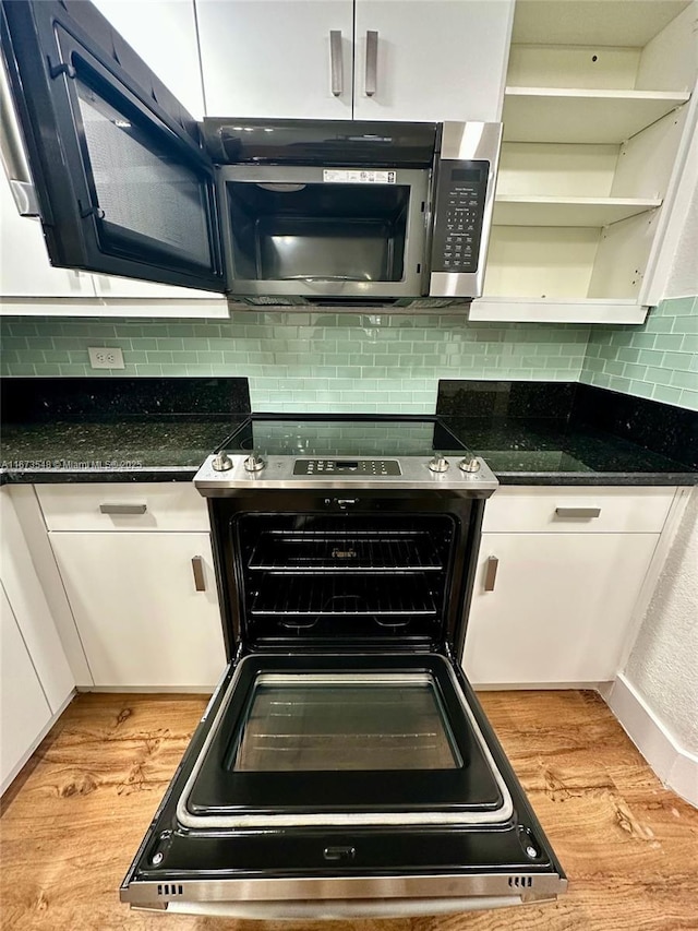 kitchen featuring white cabinetry, light hardwood / wood-style flooring, tasteful backsplash, and stove