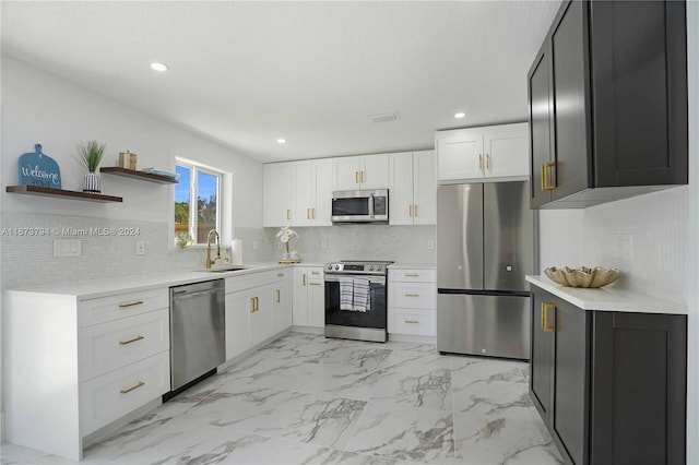 kitchen with decorative backsplash, sink, white cabinetry, and stainless steel appliances