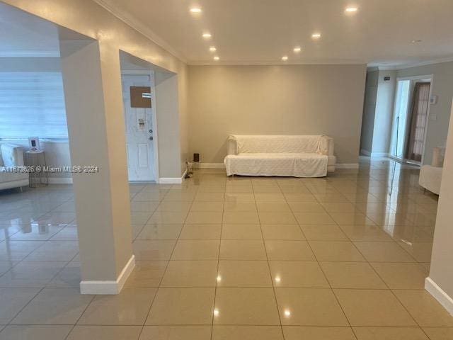 unfurnished living room featuring ornamental molding, a healthy amount of sunlight, and light tile patterned floors