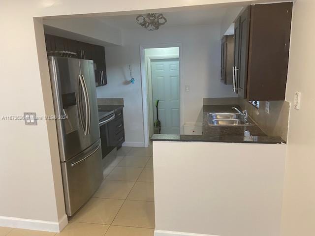 kitchen featuring dark brown cabinets, light tile patterned floors, a notable chandelier, stainless steel refrigerator with ice dispenser, and sink