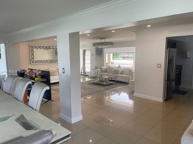 living room with ornamental molding and light tile patterned floors