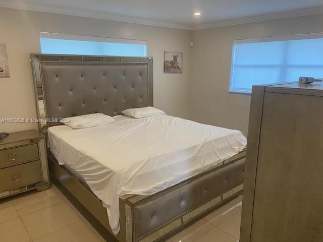 bedroom with crown molding, light tile patterned flooring, and multiple windows