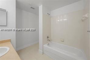 bathroom with tile patterned floors, vanity, and shower / washtub combination