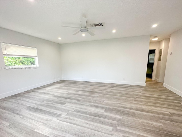 spare room featuring ceiling fan, a textured ceiling, and light wood-type flooring