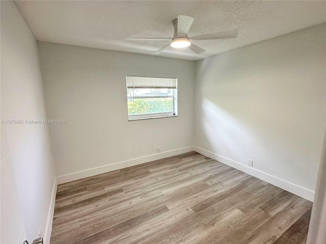 empty room featuring light hardwood / wood-style floors, a textured ceiling, and ceiling fan