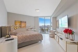 tiled bedroom featuring a wall of windows and access to outside