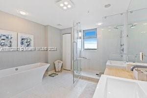 bathroom featuring independent shower and bath, vanity, and tile patterned flooring