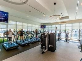 exercise room featuring a tray ceiling and floor to ceiling windows