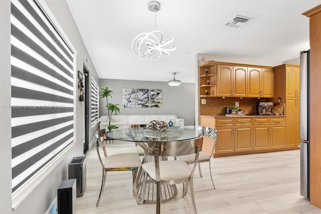 dining room featuring an inviting chandelier and light hardwood / wood-style flooring