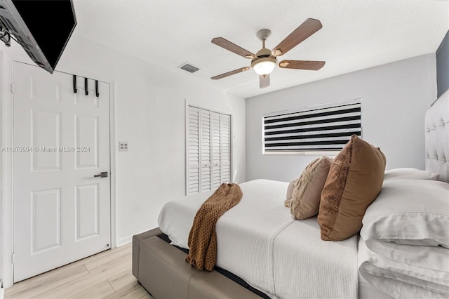 bedroom featuring ceiling fan, a closet, and light hardwood / wood-style flooring