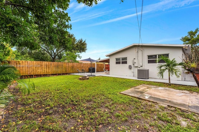 view of yard with central AC and a patio