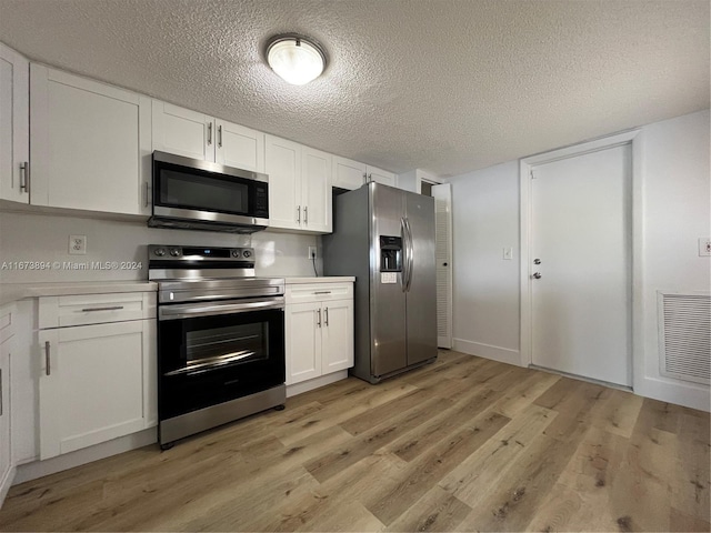 kitchen featuring white cabinetry, light hardwood / wood-style flooring, a textured ceiling, and appliances with stainless steel finishes