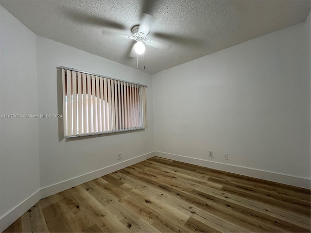 unfurnished room featuring ceiling fan, light wood-type flooring, and a textured ceiling