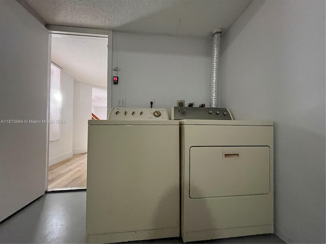 laundry room featuring a textured ceiling and washing machine and dryer