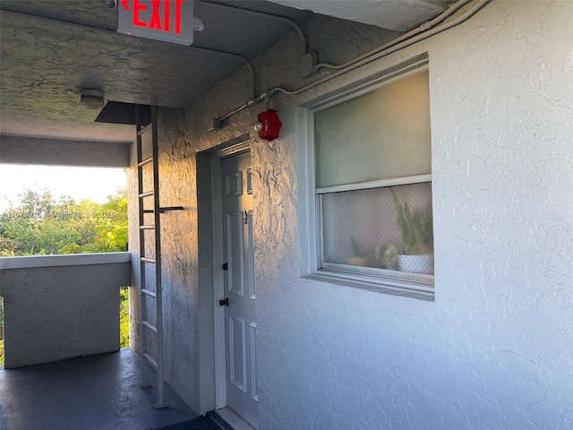 doorway to property featuring stucco siding