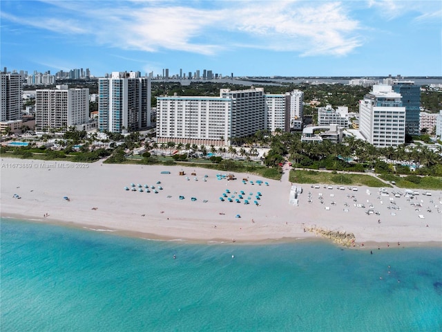 bird's eye view featuring a water view, a city view, and a beach view