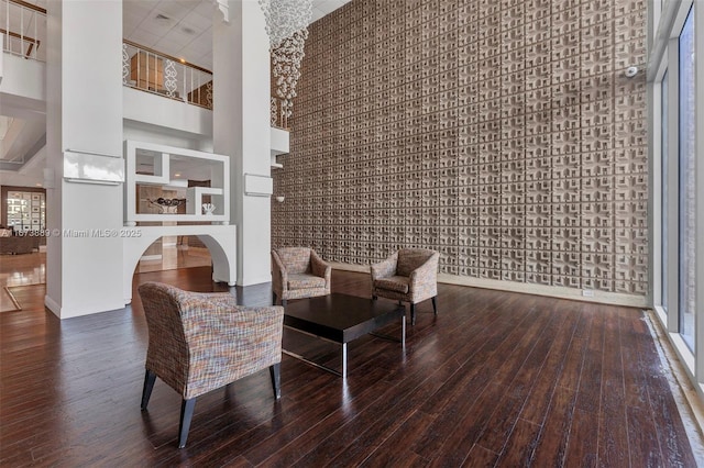 living area featuring hardwood / wood-style floors and a towering ceiling