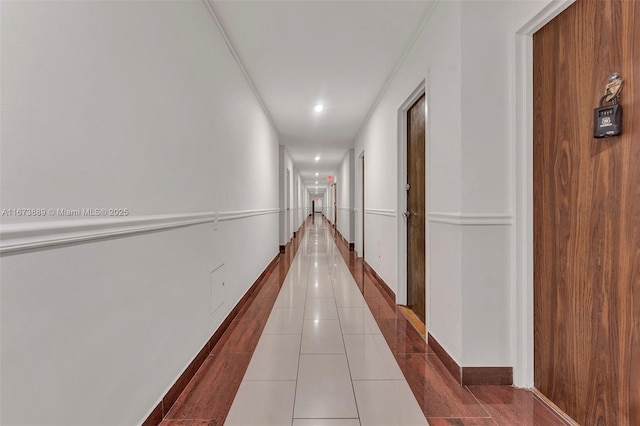 hall featuring tile patterned floors and baseboards