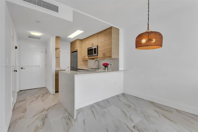 kitchen with visible vents, a sink, light countertops, appliances with stainless steel finishes, and marble finish floor