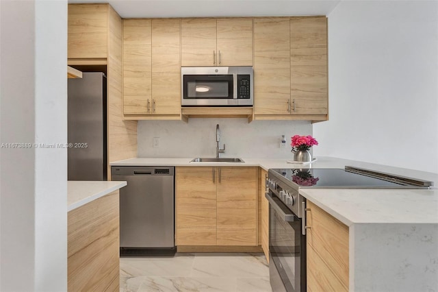 kitchen featuring light brown cabinets, a sink, light countertops, appliances with stainless steel finishes, and marble finish floor