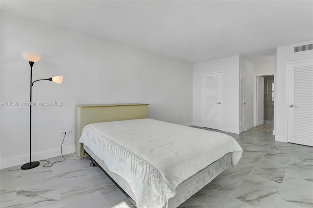 bedroom with visible vents, baseboards, marble finish floor, and a closet