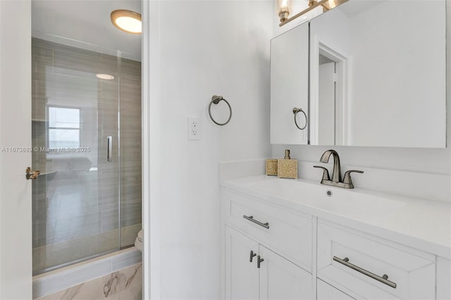 bathroom with vanity, a shower with shower door, and toilet