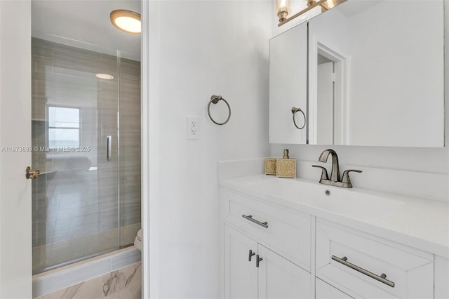 full bath featuring toilet, a stall shower, and vanity