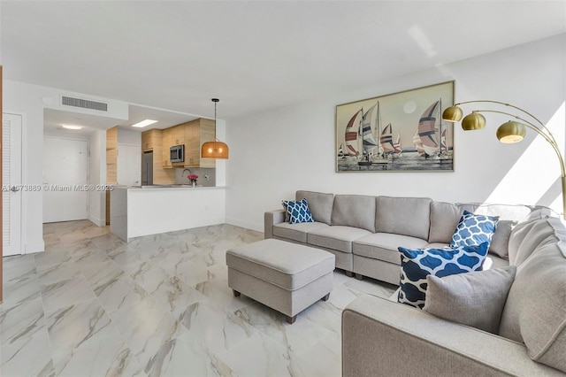 living area featuring visible vents, baseboards, and marble finish floor