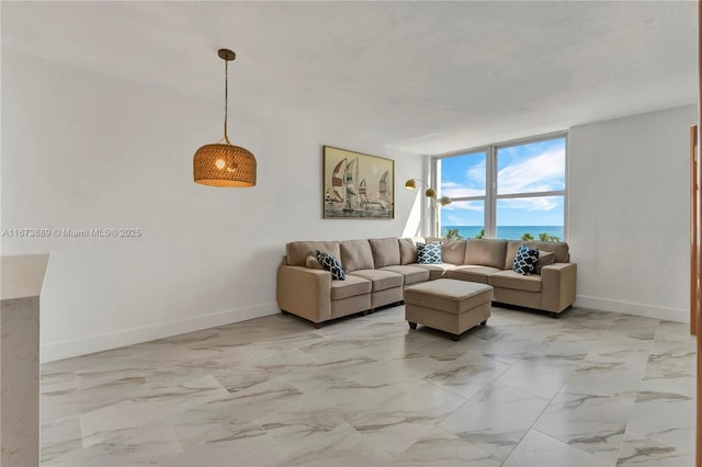 living area featuring baseboards, marble finish floor, and floor to ceiling windows