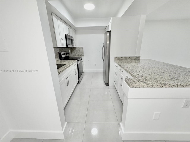 kitchen featuring decorative backsplash, white cabinetry, light stone counters, and appliances with stainless steel finishes