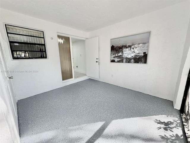 unfurnished room with a textured ceiling