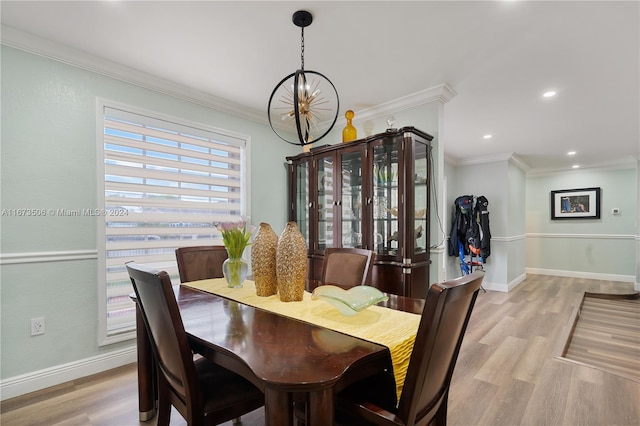 dining space with a chandelier, crown molding, and light hardwood / wood-style flooring