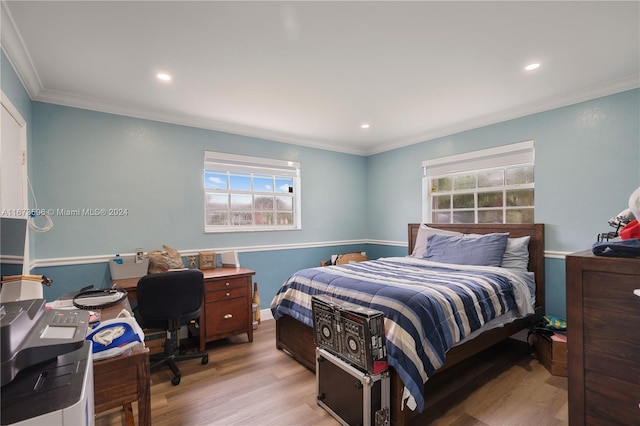 bedroom with light wood-type flooring and crown molding