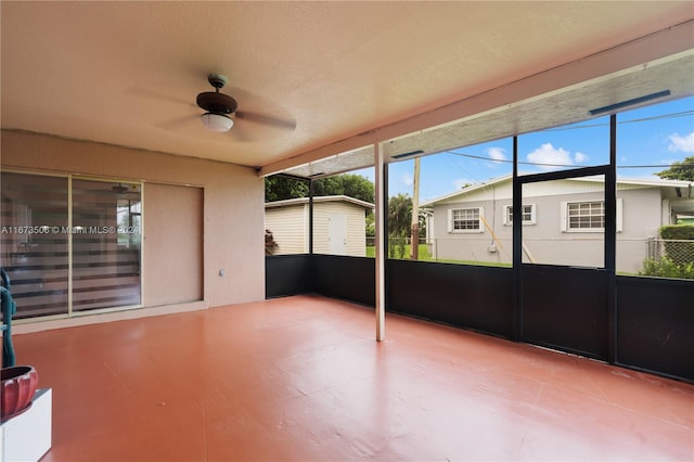 unfurnished sunroom featuring ceiling fan