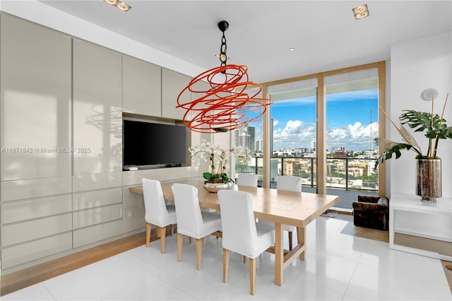 tiled dining room featuring floor to ceiling windows