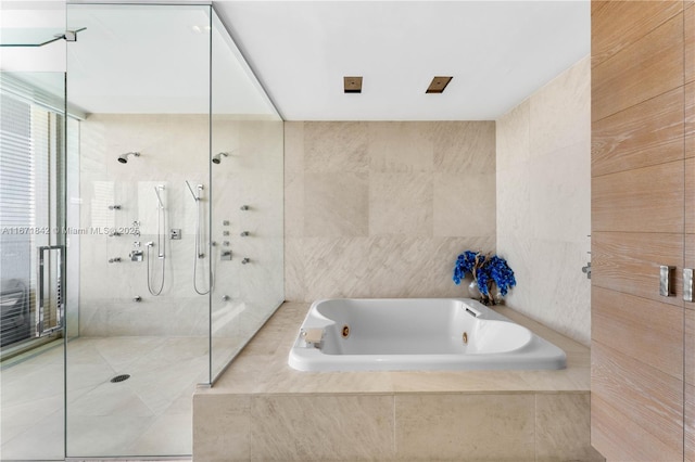 800 S Pointe Dr Unit 901, Miami Beach, FL 33139 - bathroom with tiled shower, a jetted tub, tile walls, and tile patterned floors