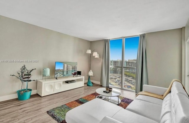 3801 S Ocean Dr Unit 9W, Hollywood, FL 33019 - living room featuring baseboards, wood finished floors, and a wall of windows