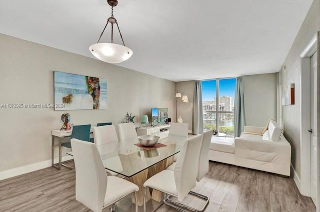 3801 S Ocean Dr Unit 9W, Hollywood, FL 33019 - dining space featuring a wall of windows, baseboards, and light wood-style flooring