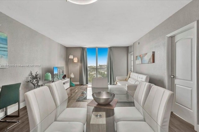 3801 S Ocean Dr Unit 9W, Hollywood, FL 33019 - dining space with a wall of windows, baseboards, a textured wall, and wood finished floors