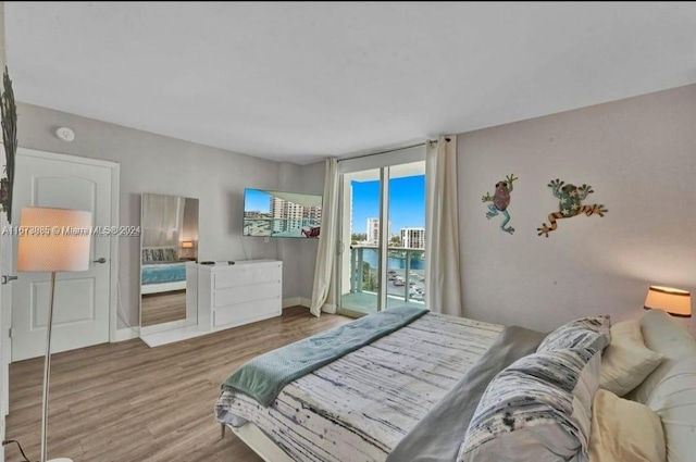 bedroom with wood-type flooring and access to outside