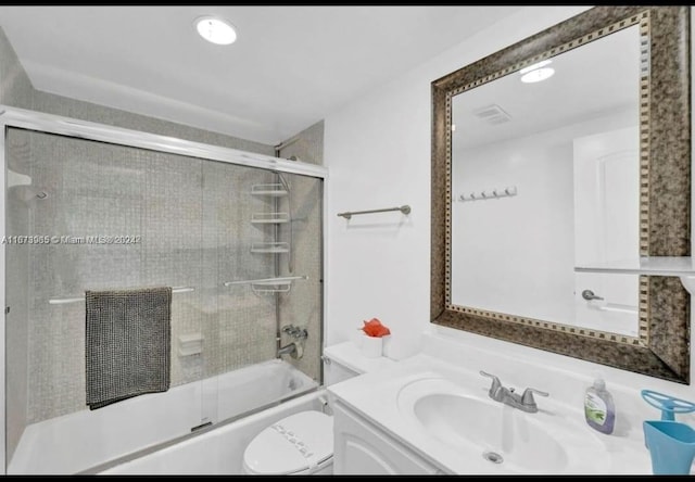 full bathroom with shower / bath combination with glass door, vanity, and toilet