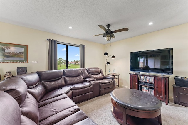 living room featuring ceiling fan, a textured ceiling, and light colored carpet