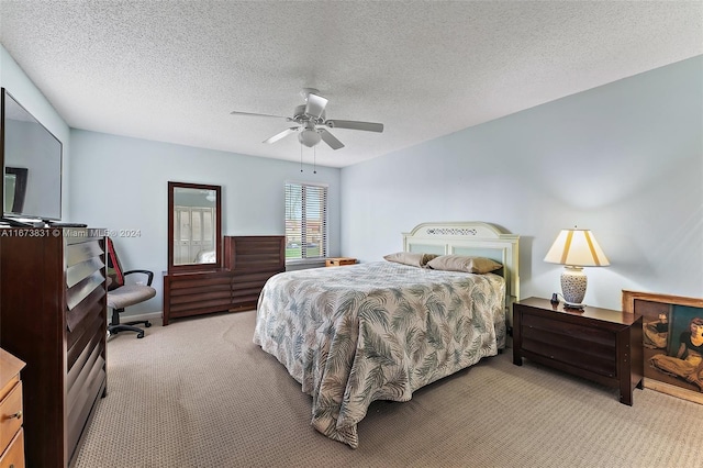 carpeted bedroom with ceiling fan and a textured ceiling