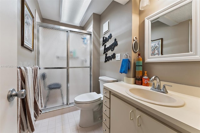 bathroom with vanity, a shower with shower door, toilet, and tile patterned floors