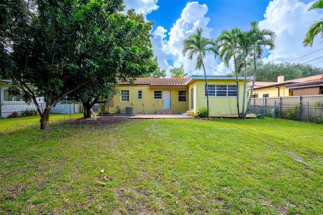 back of property featuring central AC unit and a lawn