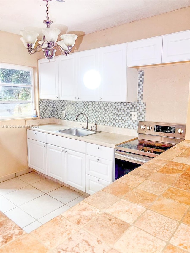 kitchen with stainless steel electric stove, tasteful backsplash, white cabinetry, sink, and hanging light fixtures