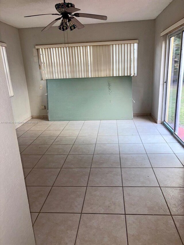 tiled empty room with ceiling fan