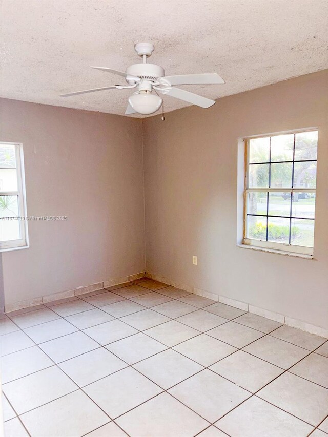 tiled spare room with ceiling fan and a textured ceiling